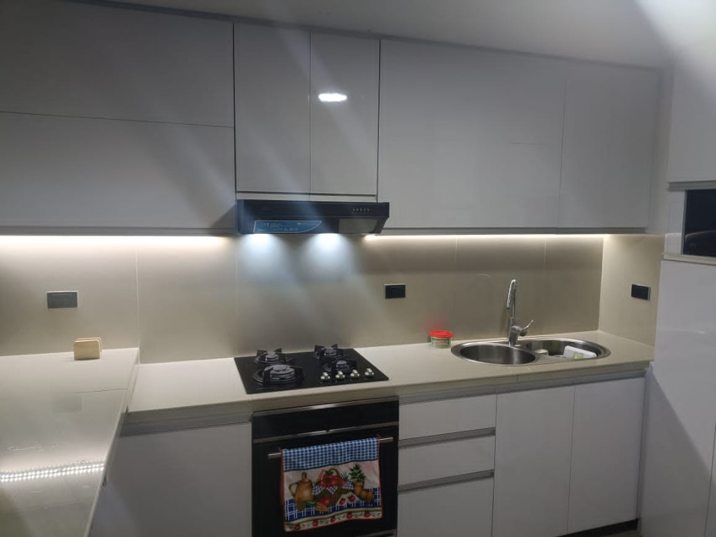 Cocina moderna en blanco brillo con campana extractora y tiras de iluminación LED