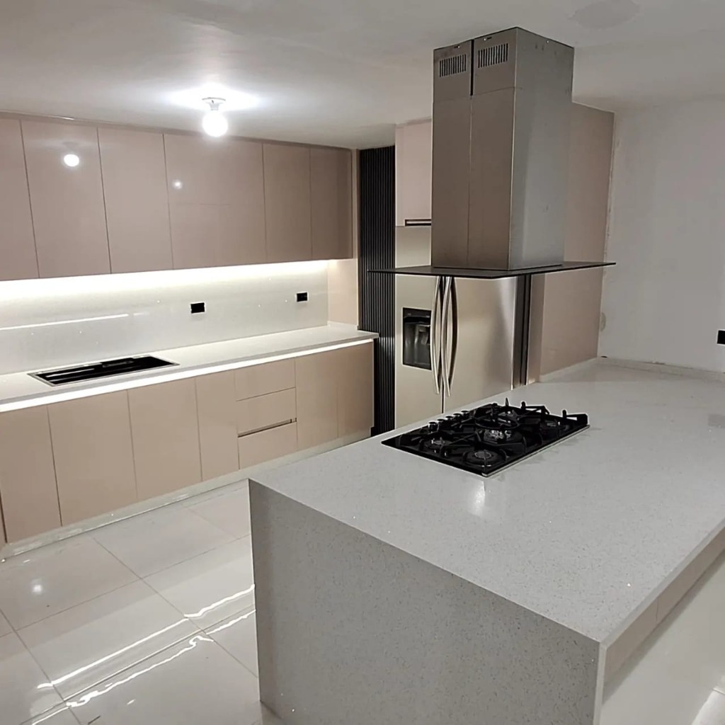 Cocina de lujo amplia con campana de isla en acero inoxidable y gabinetes beige